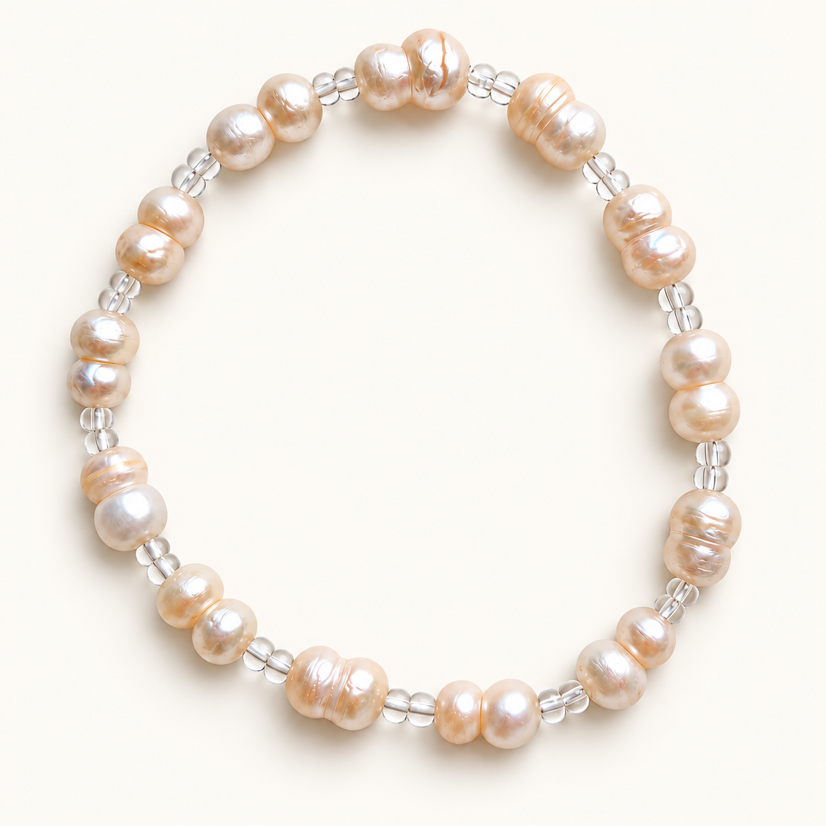 Close-up of the Clear Duo freshwater pearl stretch anklet with transparent spacer beads on warm ivory