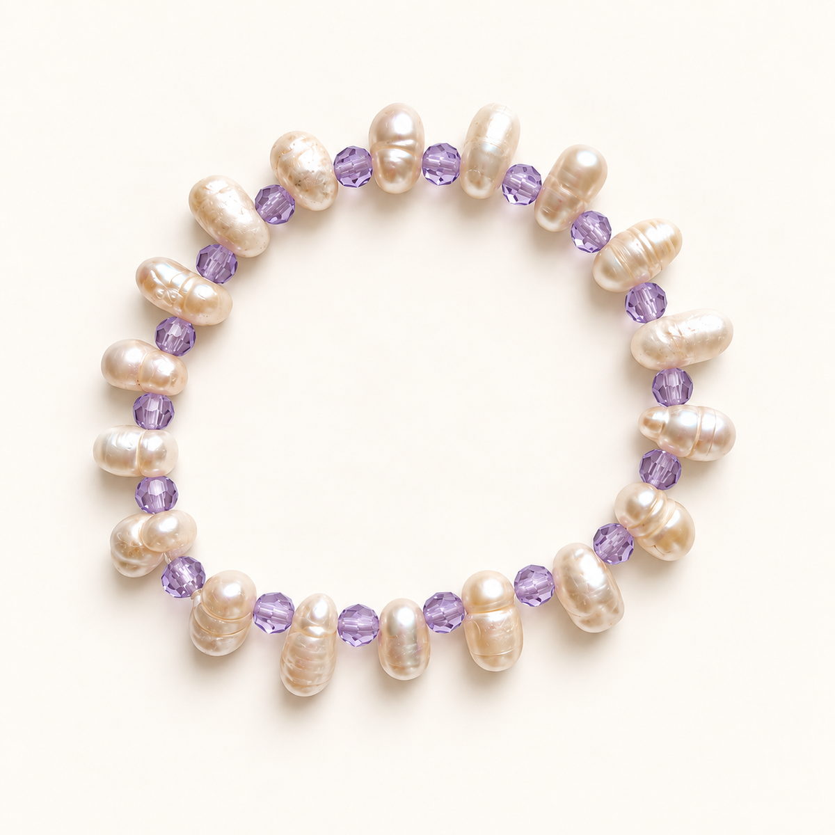 Pearl stretch anklet with faceted lavender beads on a warm ivory background