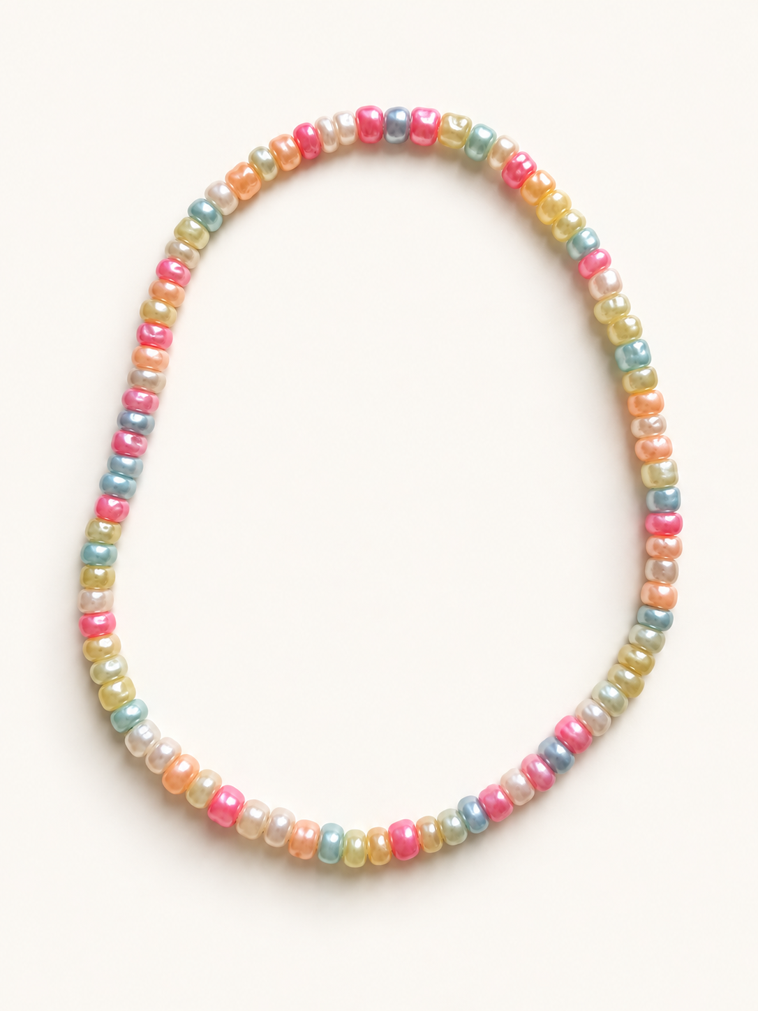 Rainbow acrylic bead stretch anklet in pink, peach, yellow, blue, and ivory on a cream background